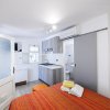 Camera con letto, cucina e bagno.