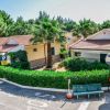Bungalow circondati da palme e siepi.